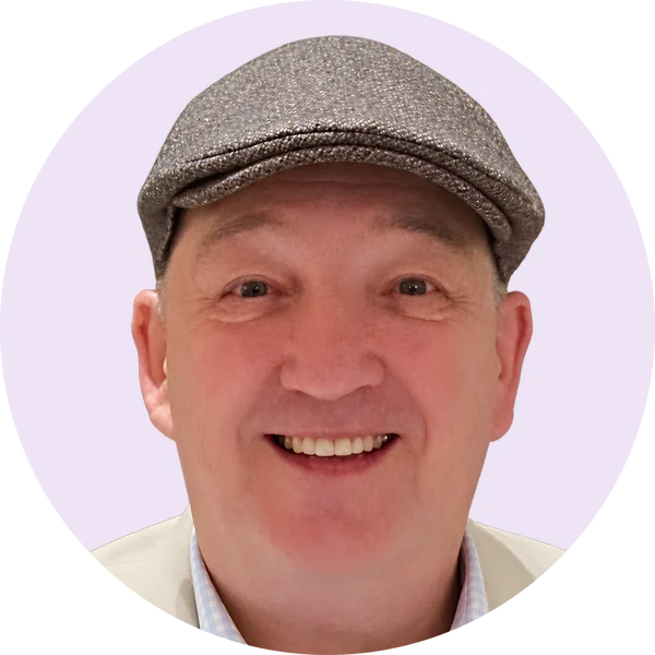 Brendan Martin, creator of Collyvale, smiling in a tweed flat cap and cream jacket